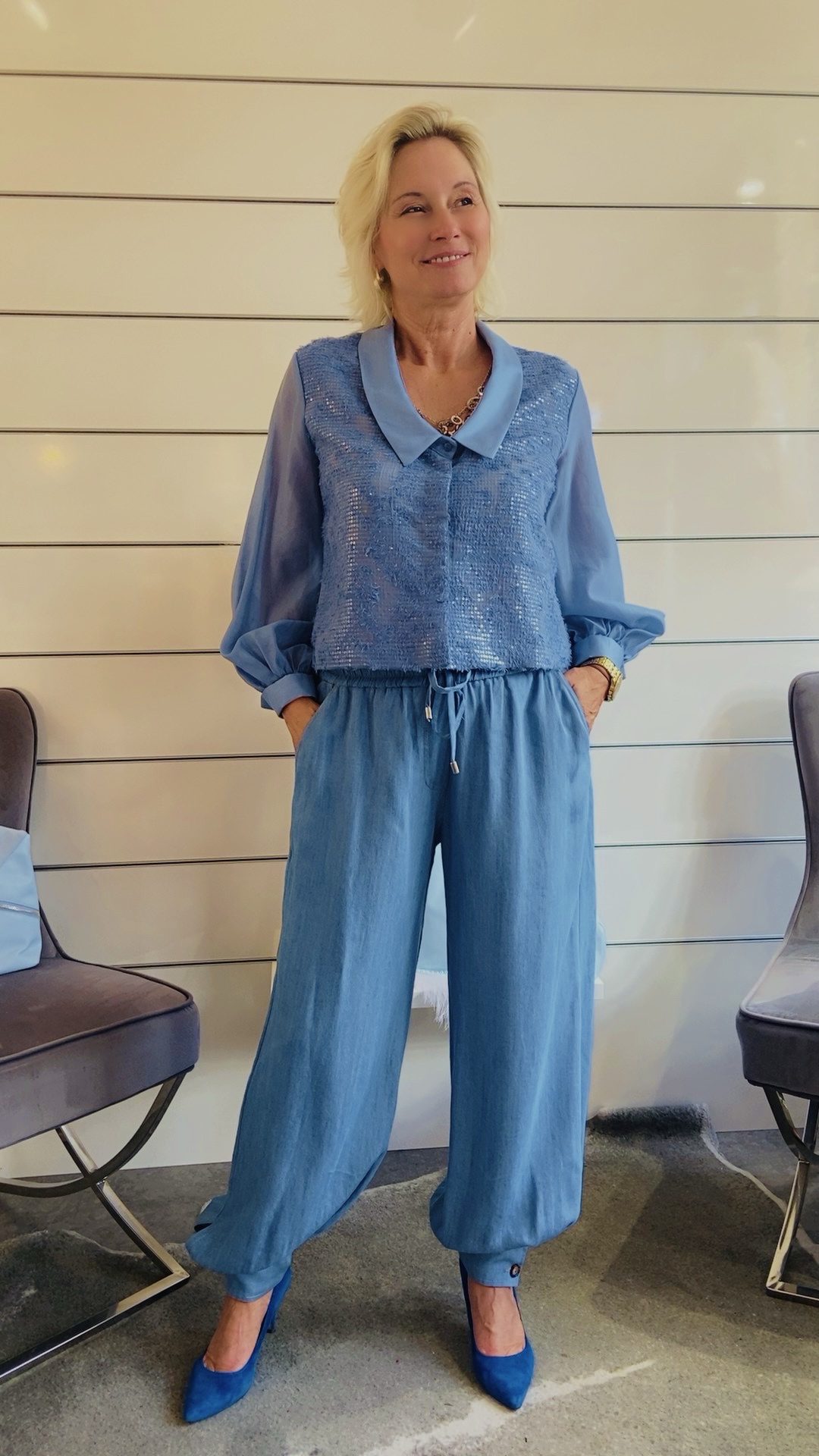 Hellblaue Paillettenbluse mit Kette am Kragen