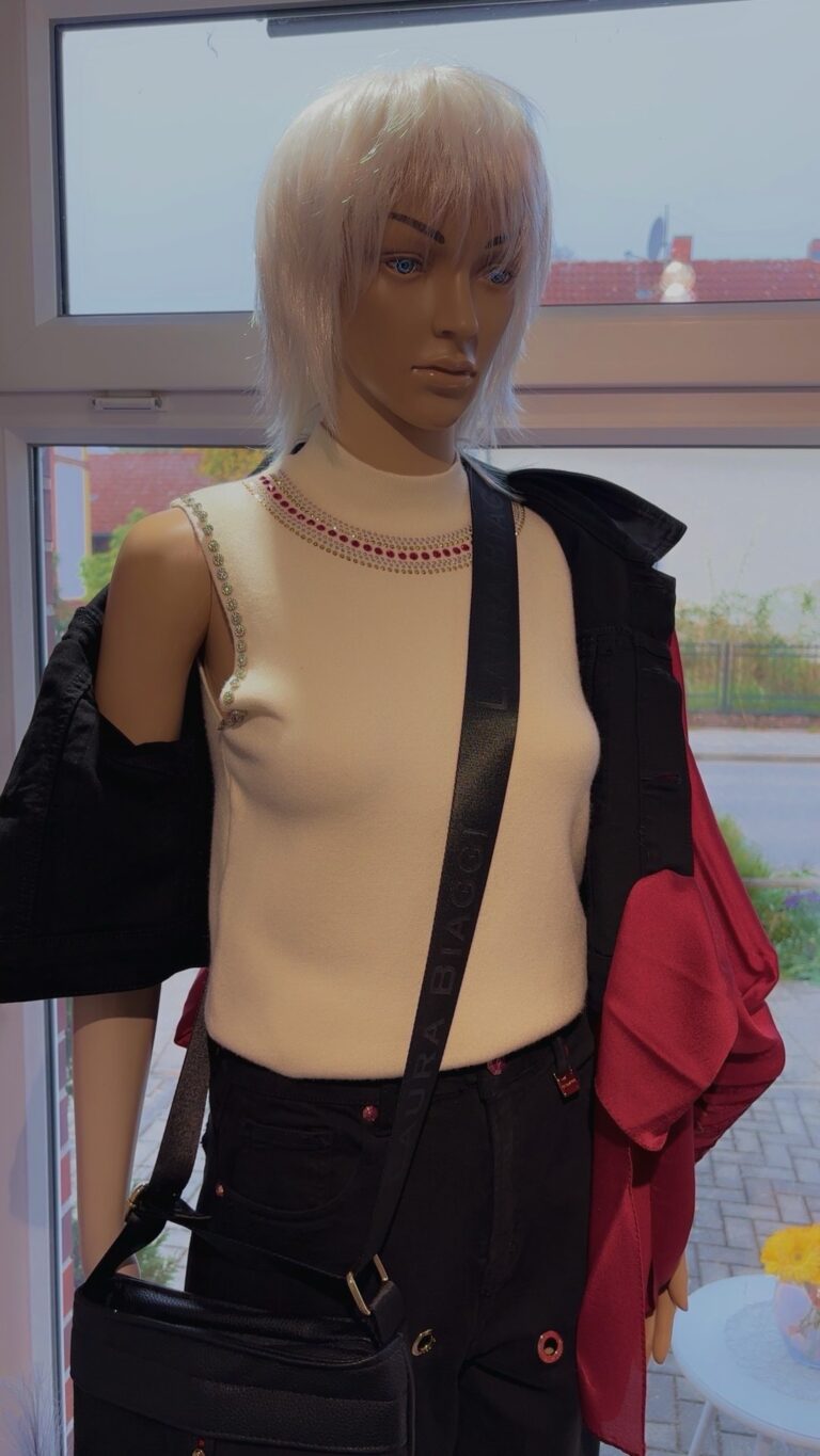 Elegantes Stricktop mit Schmuckdetails und Stehkragen